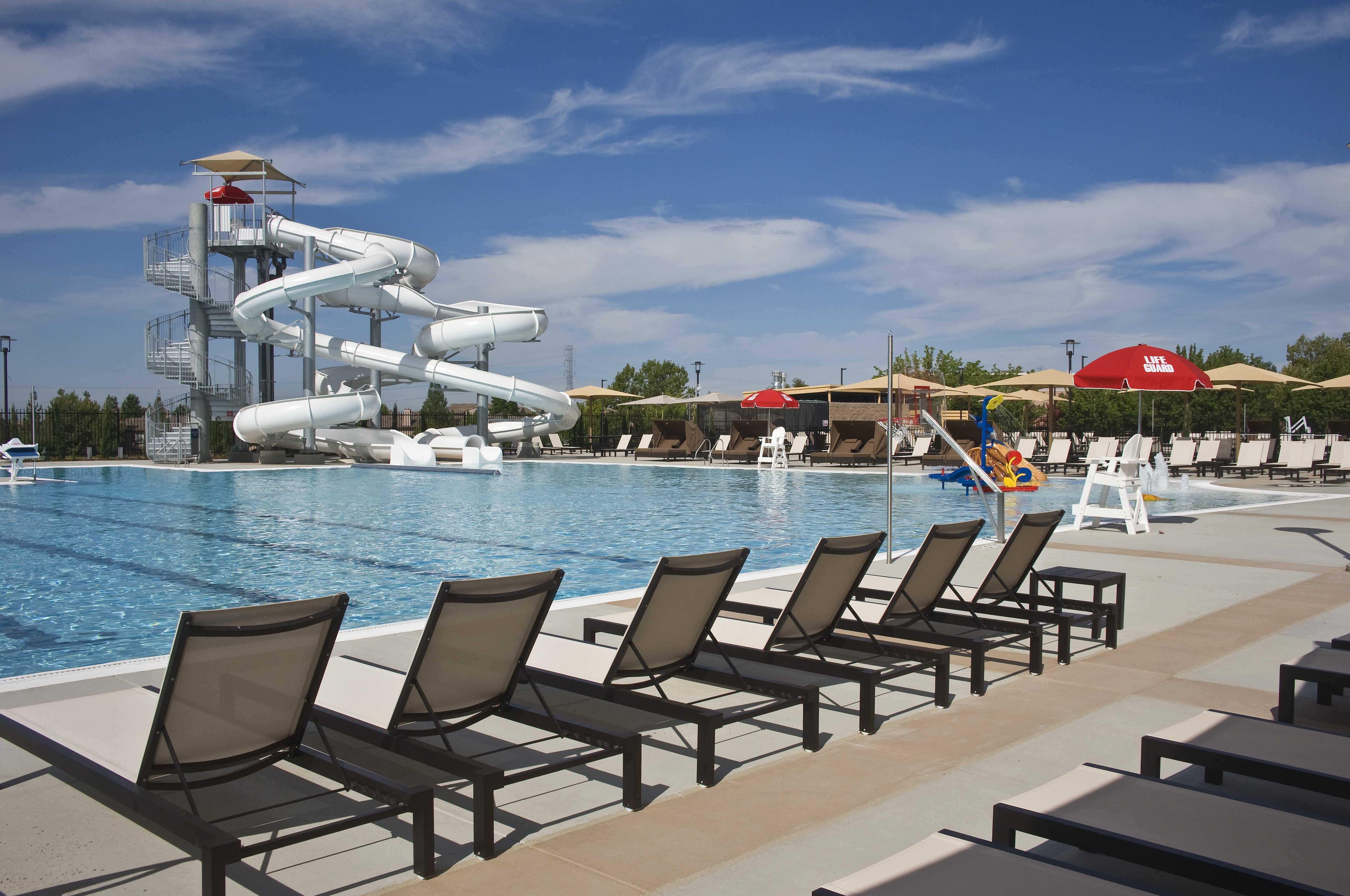 villa sport pool with waterslide and lounge chairs